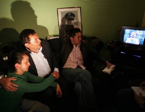  Familiares de uno de los policas colombianos secuestrados miran la prueba. 