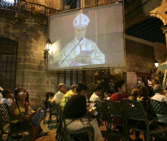 Varios catlicos cubanos siguen atentamente las palabras de Bertone en La Habana. 