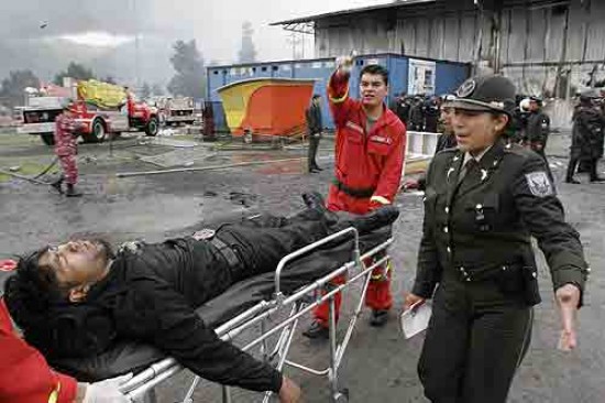 Los brigaditas transportan heridos durante el incendio de la disco en Quito.