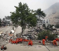 Dramáti-ca imagen cuando un rescatista extrae un cuerpo de entre las ruinas. Los rescatistas, extenuados, descansan sobre los escombros del terremoto más grave de los últimos 50 años en China.