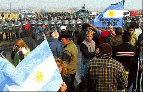 Chacareros y pobladores rodearon a la gendarmera , en medio de gran tensin. Nstor Kirchner estuvo anoche en Plaza de Mayo para respaldar las medidas de su esposa, apoyado por el gabinete y grupos K. Una imagen que impact:gendarmes arrestan a uno d elos ruralistas que estaban en la ruta de Gualeguaych, en base a una antigua orden judicial reactivada por el ministerio del Interior. Numerosas personas salieron en la Capital y otras ciudades a manifestarse con cacerolazos y marchas contra la represin a los ruralistas. Pero en la protesta en la Quinta de Olivos fueron expulsados por un grupo de violentos al ritmo de la marcha peronista.