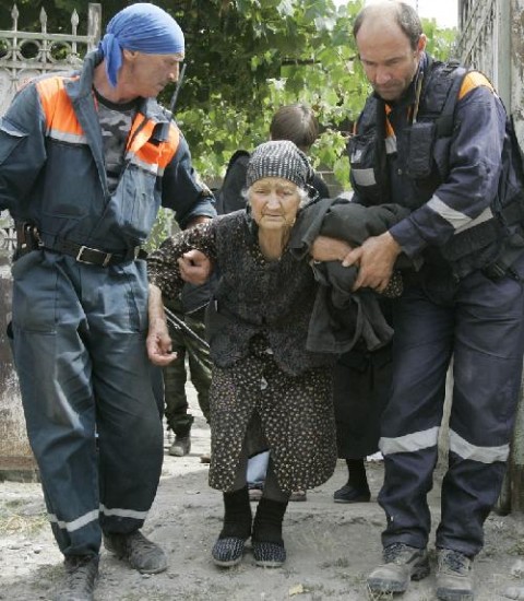 Una pobladora de Osetia del Sur es asistida por tropas rusas. Un comité de investigación ruso anunció que 133 civiles fueron registrados como muertos en el conflicto con Georgia.