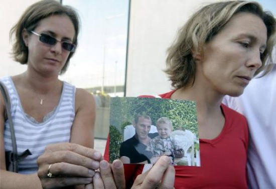 Una ciudadana francesa que aguarda la identificación de los cuerpos muestra la foto de su esposo e hijo, fallecidos en el accidente.