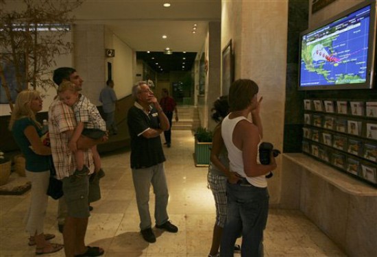 Pobladores miran las noticias con la última información del paso del huracán. (FOTO: AP)