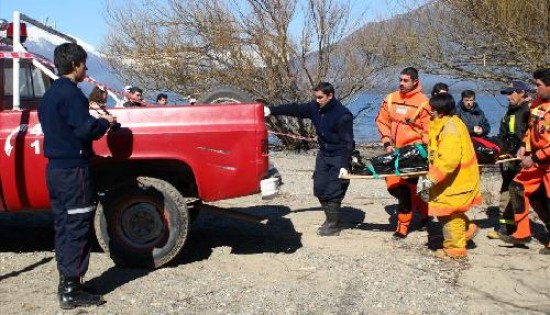 El cuerpo de Ziga es traslada-do luego de su hallazgo casi en la desembocadura del Azul en el lago Puelo.