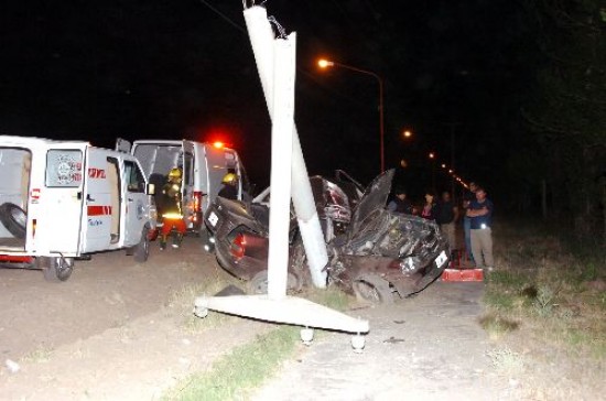 El poste de cemento destruido, el auto partido casi en la mitad, dan idea de la fuerza del impacto. 