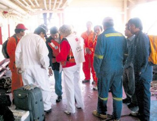 Miembros de la Cruz Roja verifican el estado de salud de los marineros. 