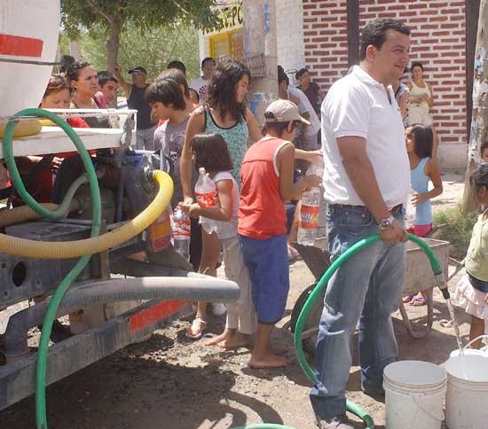 Vecinos reparten agua de los camiones detenidos. (Foto de Gaby Oyarzo)