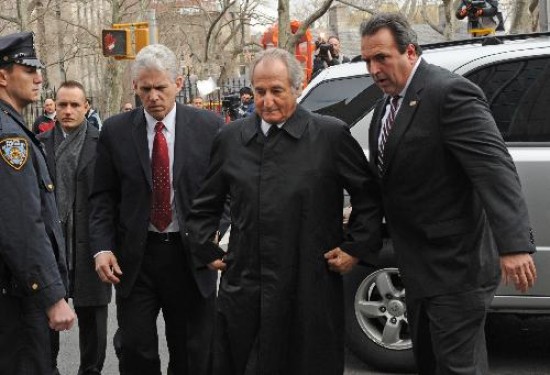 Madoff (centro), con rostro distendido pero fuertemente custodiado al acercarse a los tribunales, se prepara para su sentencia. 