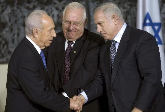 El nuevo jefe de gobierno de Israel (der.), durante la ceremonia de transferencia del poder. Lo saluda Shimon Peres (izq.). 
