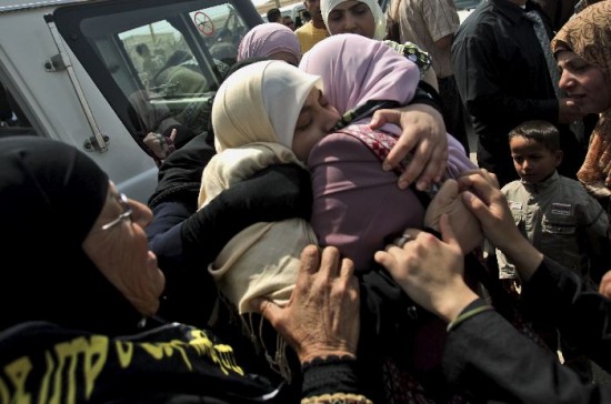 Una de las 19 palestinas liberadas ayer se saluda con sus familiares. 