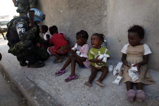 El reparto de comida y agua a los nios es una de las prioridades. La tarea se hace bajo fuerte custodia para que no los despojen. Haitianos se apresuran a sacar de edificios en ruinas todo lo que pudiera serles til. 